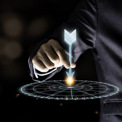 Businessman hand holding and throwing virtual dart to target board on black background.Business and investment target concept.