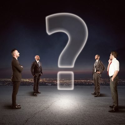 Team of businesspeople watch together a big question mark
